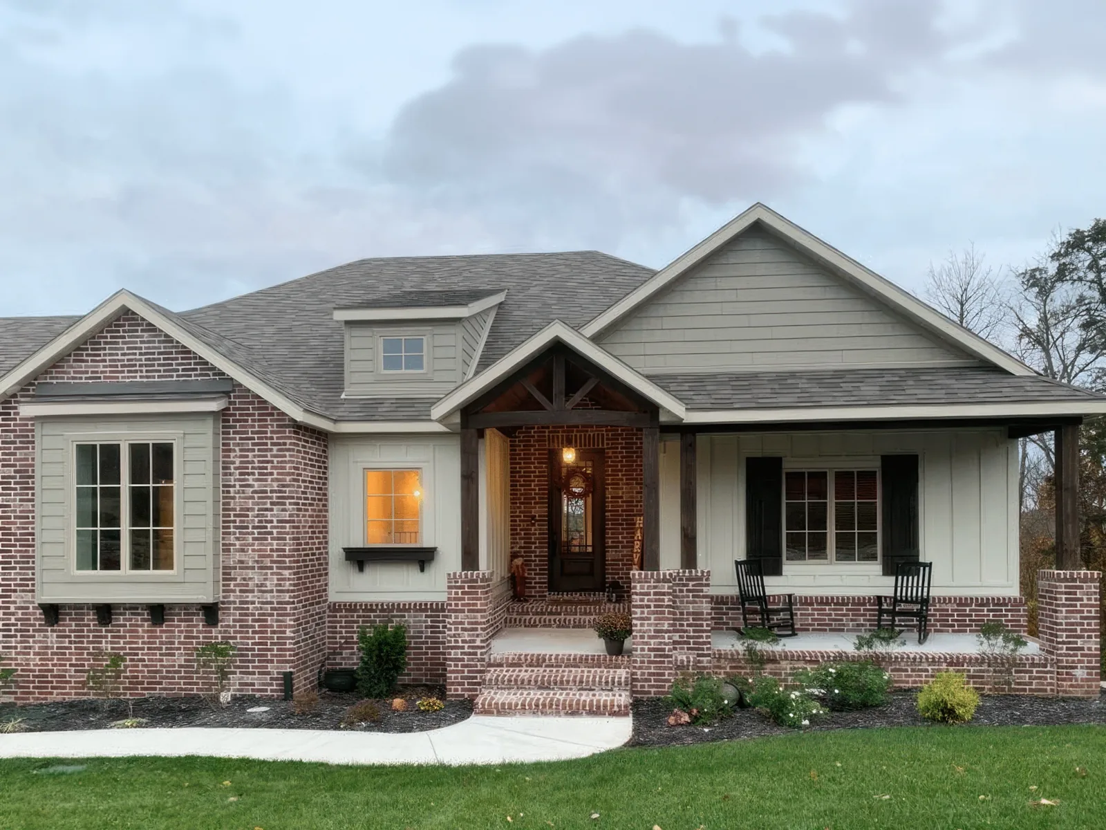Freshly painted brick craftsman home with covered porch in Southwest Missouri